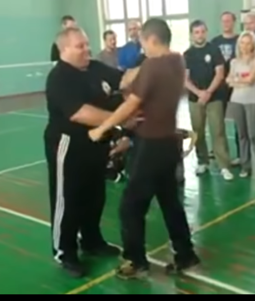 Portly Systema instructor pokes at a few pressure points on training partner.