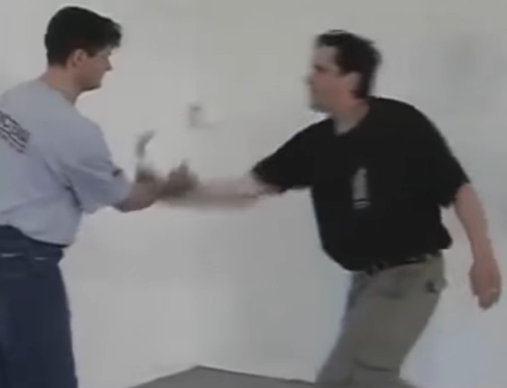 Systema instructor strikes at the wrist of the assailant to disarm the knife.