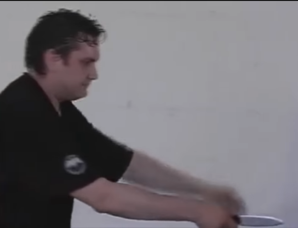 Systema instructor moves forward to avoid being stabbed in the back, training partner just stands there. 